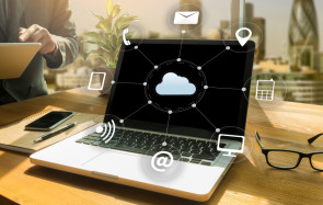 Laptop auf Tisch mit Cloud-Computing-Symbolen 